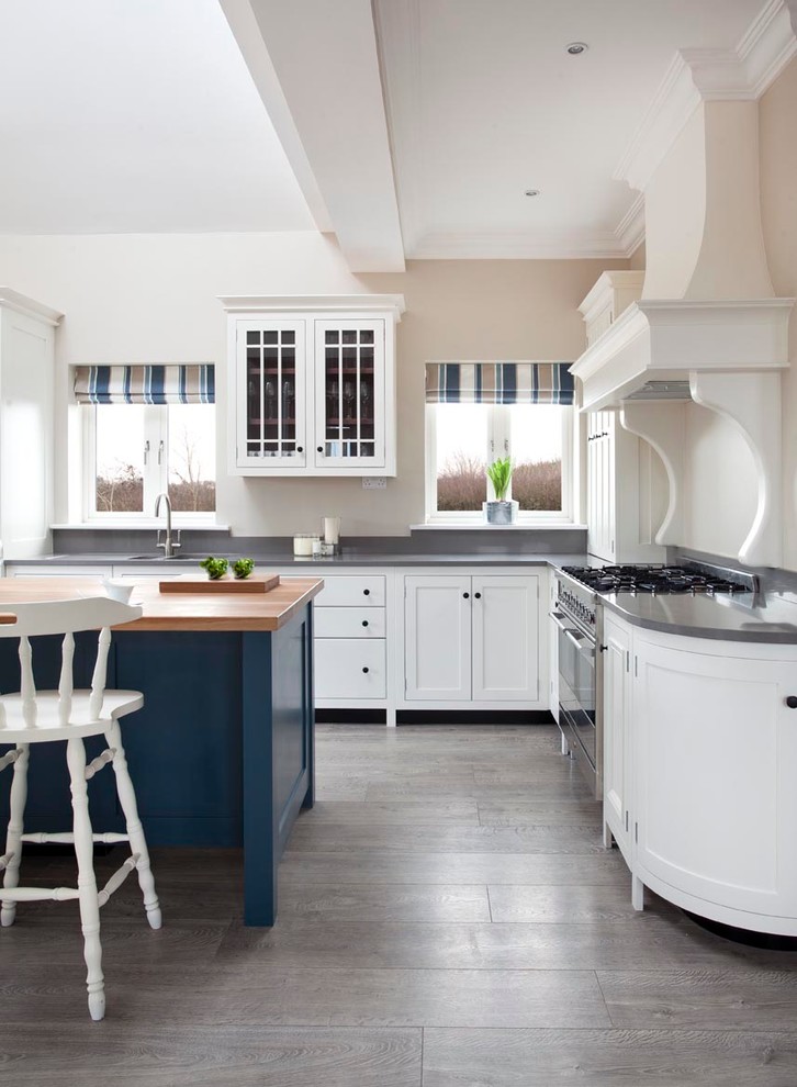 This is an example of a traditional l-shaped kitchen in Other with shaker cabinets, white cabinets, grey splashback, stainless steel appliances and with island.