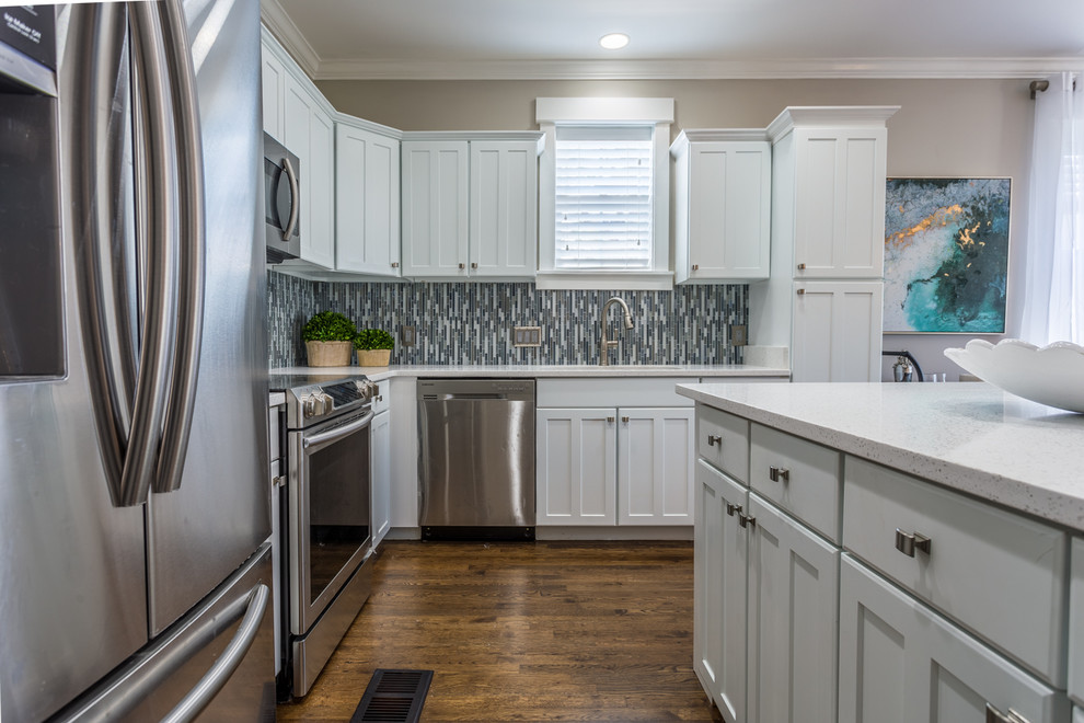 Example of a mid-sized transitional l-shaped dark wood floor and brown floor open concept kitchen design in Miami with an undermount sink, shaker cabinets, white cabinets, quartz countertops, multicolored backsplash, mosaic tile backsplash, stainless steel appliances and an island