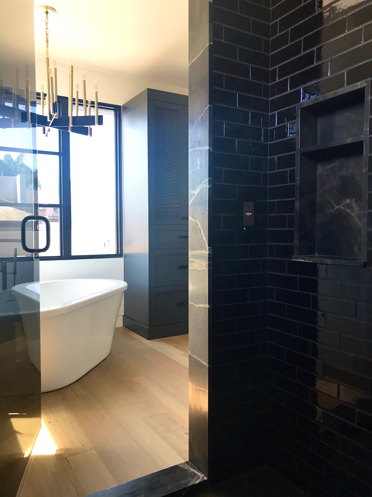 Стильный дизайн: главная ванная комната среднего размера в стиле модернизм с фасадами в стиле шейкер, черными фасадами, отдельно стоящей ванной, душевой комнатой, черной плиткой, керамической плиткой, белыми стенами, светлым паркетным полом, накладной раковиной, мраморной столешницей, коричневым полом, душем с распашными дверями, коричневой столешницей, тумбой под две раковины и встроенной тумбой - последний тренд