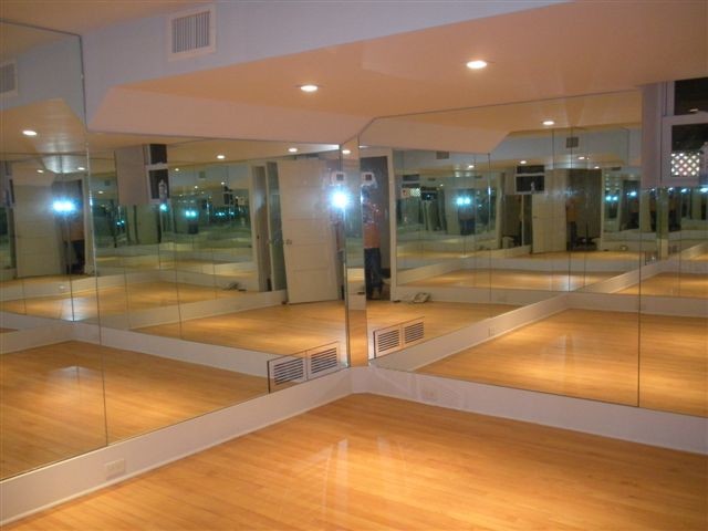 Inspiration for a large contemporary home yoga studio in New York with white walls and light hardwood floors.