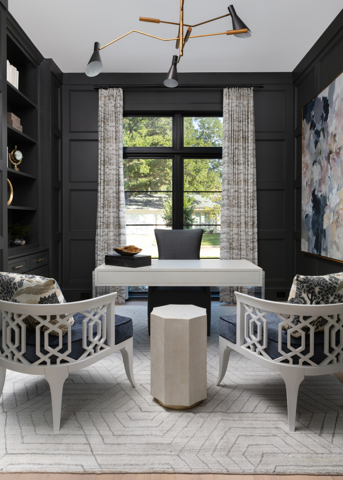 Ejemplo de despacho clásico renovado con paredes negras, suelo de madera clara, escritorio independiente, suelo beige y panelado