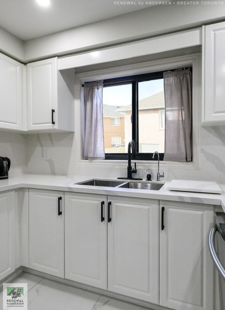 This is an example of a mid-sized u-shaped eat-in kitchen in Toronto with a double-bowl sink, white cabinets, marble benchtops, white splashback, marble splashback, stainless steel appliances, marble floors, white floor and white benchtop.