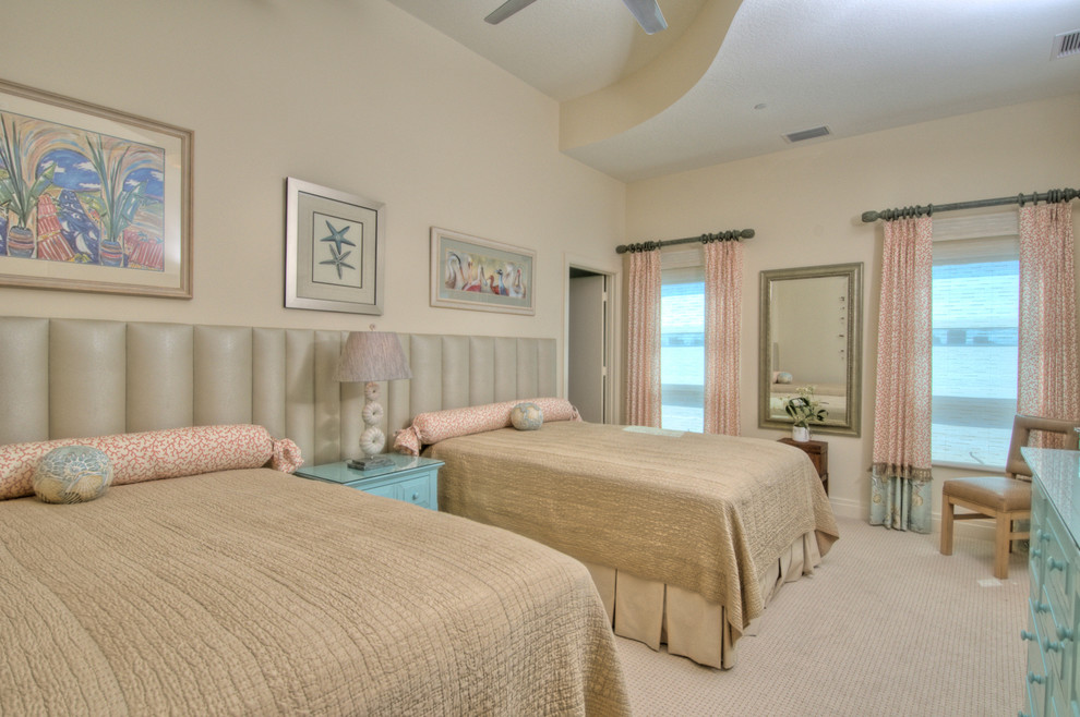 Large tropical guest bedroom in Tampa with beige walls, carpet and no fireplace.