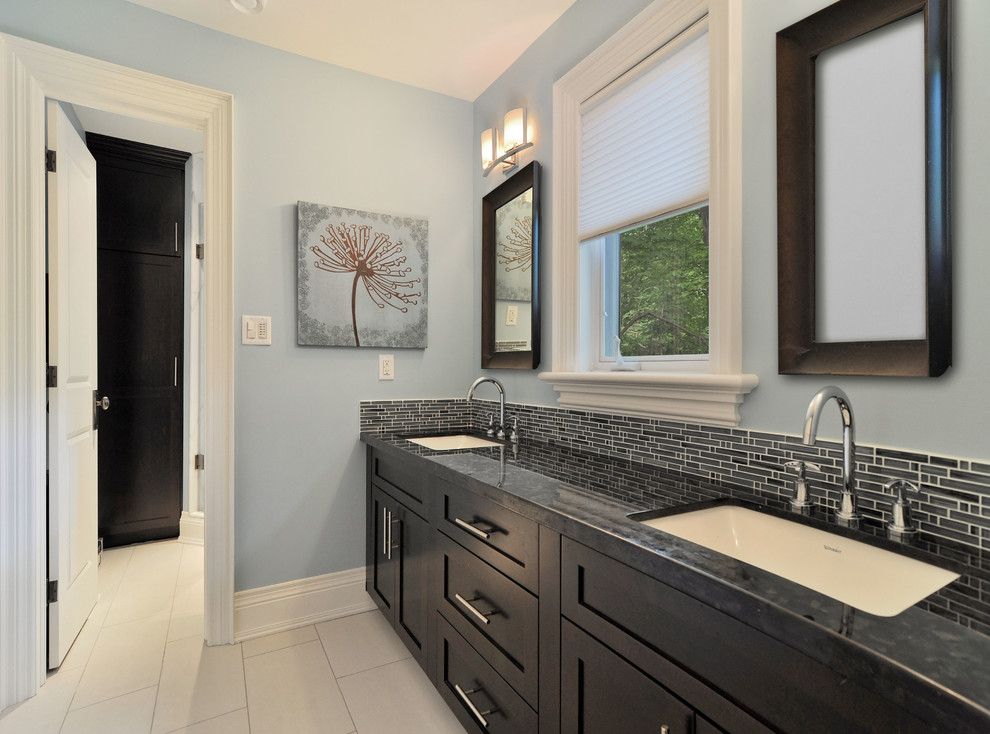 Photo of a large traditional master bathroom in Toronto with an undermount sink, shaker cabinets, black cabinets, solid surface benchtops, gray tile, ceramic tile, blue walls and porcelain floors.