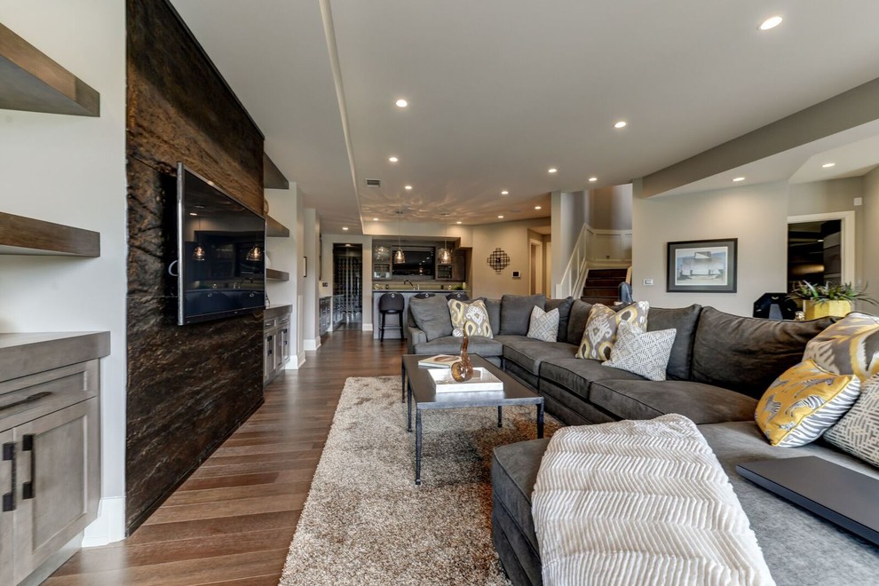 Inspiration for a large transitional open concept family room in Calgary with a home bar, grey walls, light hardwood floors, no fireplace, a built-in media wall and brown floor.