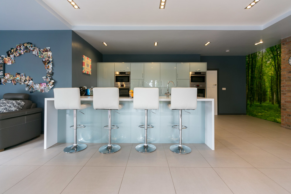 Large modern u-shaped eat-in kitchen in Other with an integrated sink, glass-front cabinets, blue cabinets, solid surface benchtops, stainless steel appliances, ceramic floors and with island.