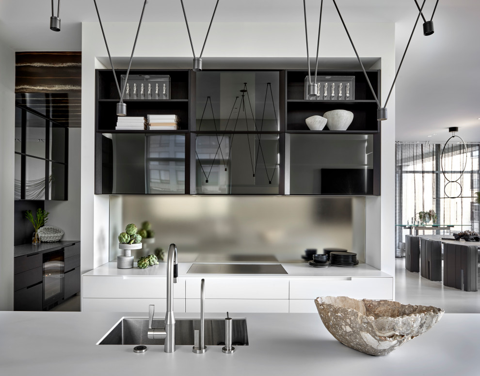 Ispirazione per una cucina contemporanea con lavello sottopiano, ante di vetro, paraspruzzi a effetto metallico, paraspruzzi a specchio, pavimento in gres porcellanato, pavimento grigio e top bianco
