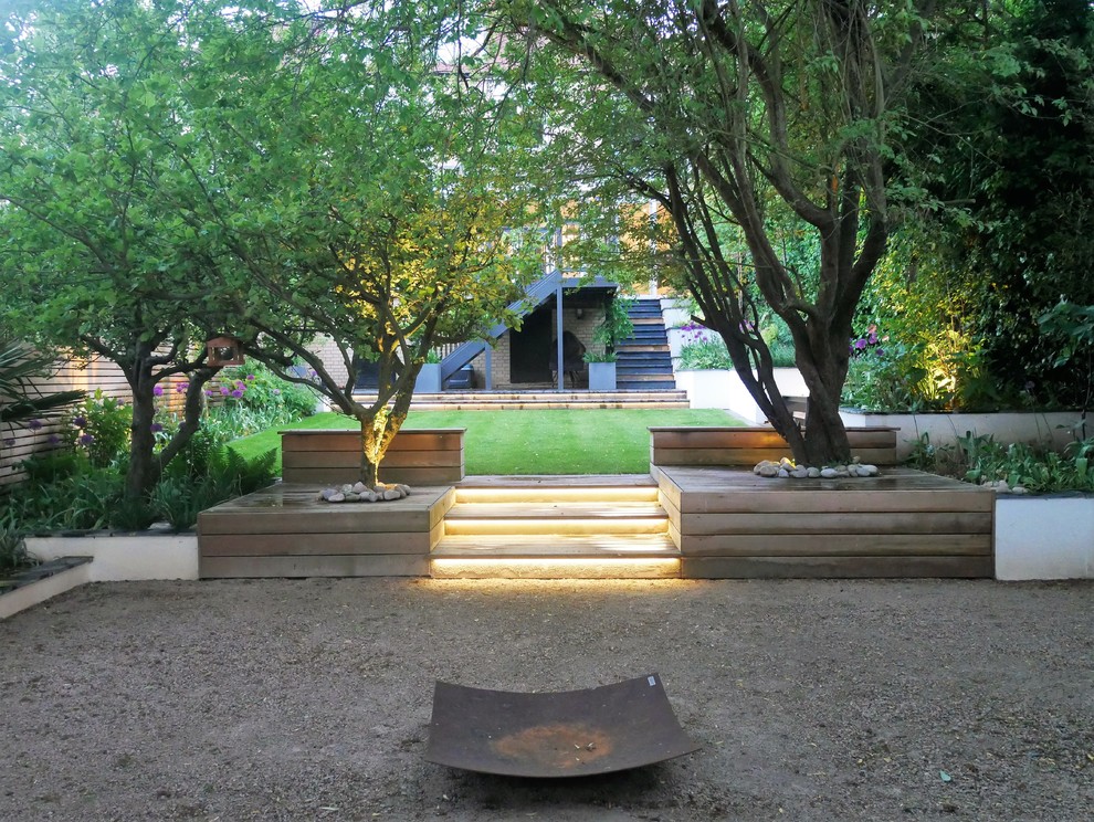 Inspiration for a contemporary backyard garden in London with a fire feature and gravel.