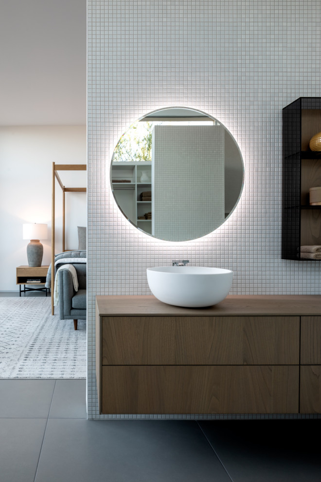 This is an example of a midcentury bathroom in Las Vegas with flat-panel cabinets, medium wood cabinets, white tile, mosaic tile, a vessel sink, wood benchtops, grey floor, brown benchtops, a double vanity and a floating vanity.