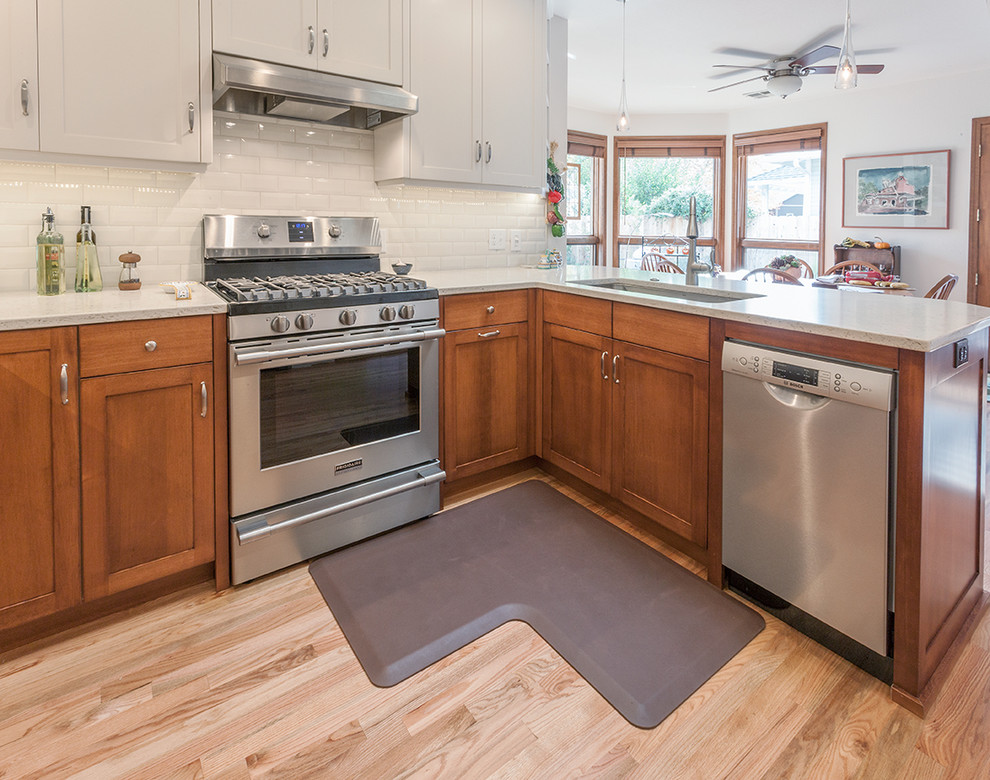 Transitional light wood floor kitchen photo with a double-bowl sink, shaker cabinets, quartz countertops, white backsplash, subway tile backsplash and stainless steel appliances