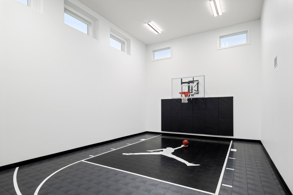 This is an example of a mid-sized country indoor sport court in Minneapolis with white walls and black floor.