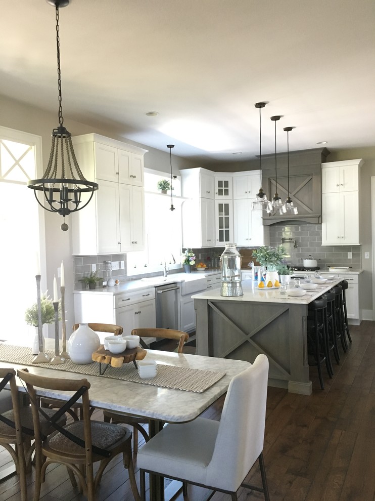 Kitchen - mid-sized transitional u-shaped kitchen idea with a farmhouse sink, recessed-panel cabinets, white cabinets, quartz countertops, gray backsplash, ceramic backsplash, stainless steel appliances and white countertops