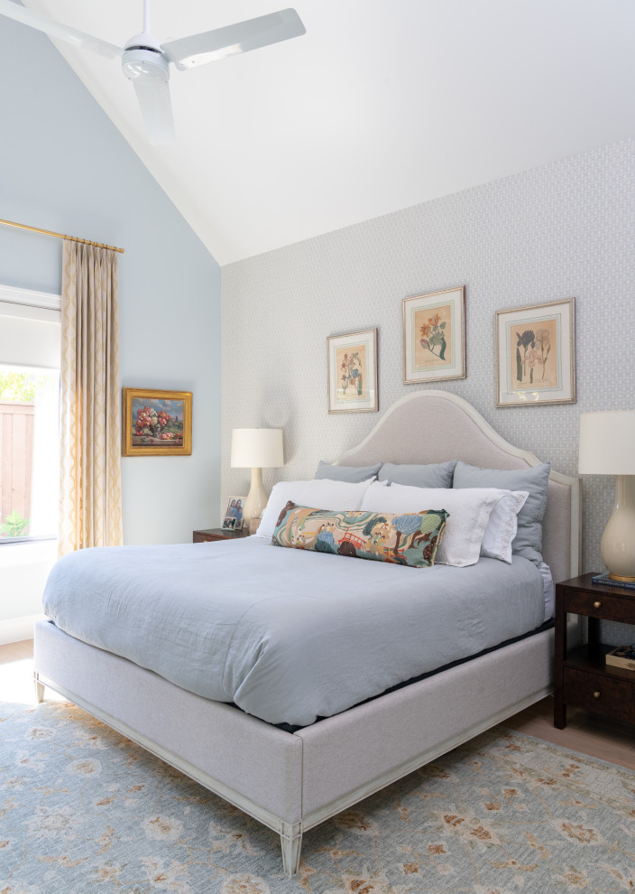This is an example of a mid-sized traditional master bedroom in Dallas with blue walls, light hardwood floors and wallpaper.