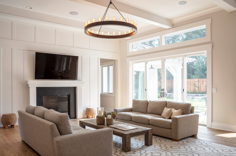 This is an example of a mid-sized country open concept living room in San Francisco with beige walls, a standard fireplace, medium hardwood floors, a stone fireplace surround and brown floor.