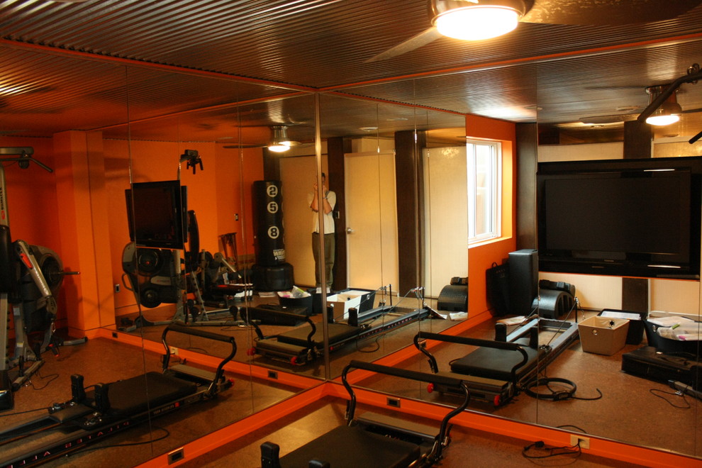 Modern home gym in Other with orange walls and cork floors.