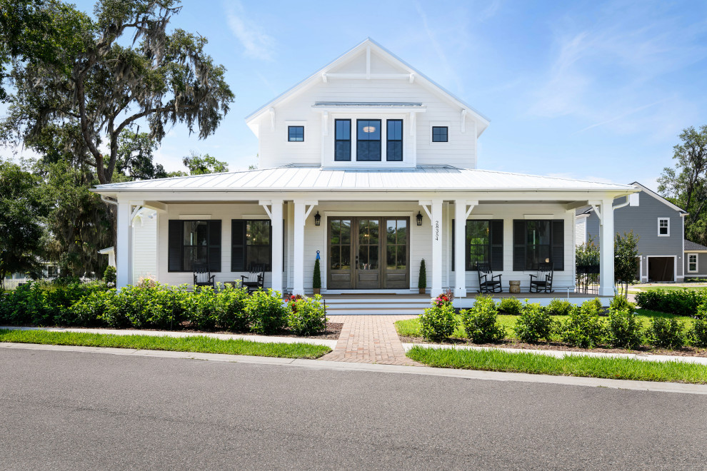 Design ideas for an expansive country two-storey white house exterior in Jacksonville with a white roof, concrete fiberboard siding, a hip roof, a metal roof and clapboard siding.