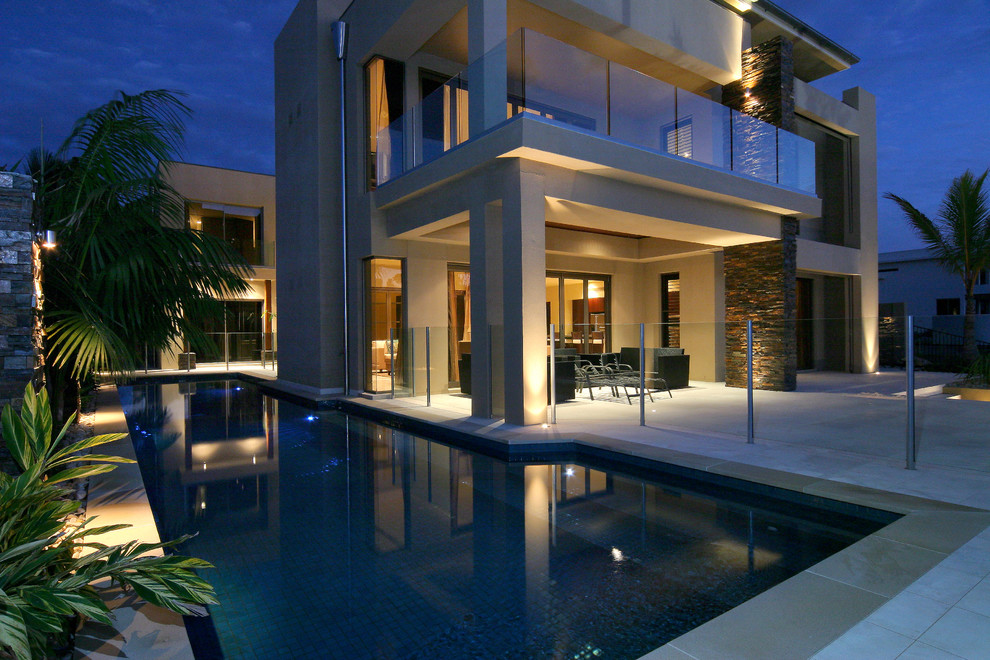 Photo of a contemporary two-storey beige house exterior in Gold Coast - Tweed with a tile roof.
