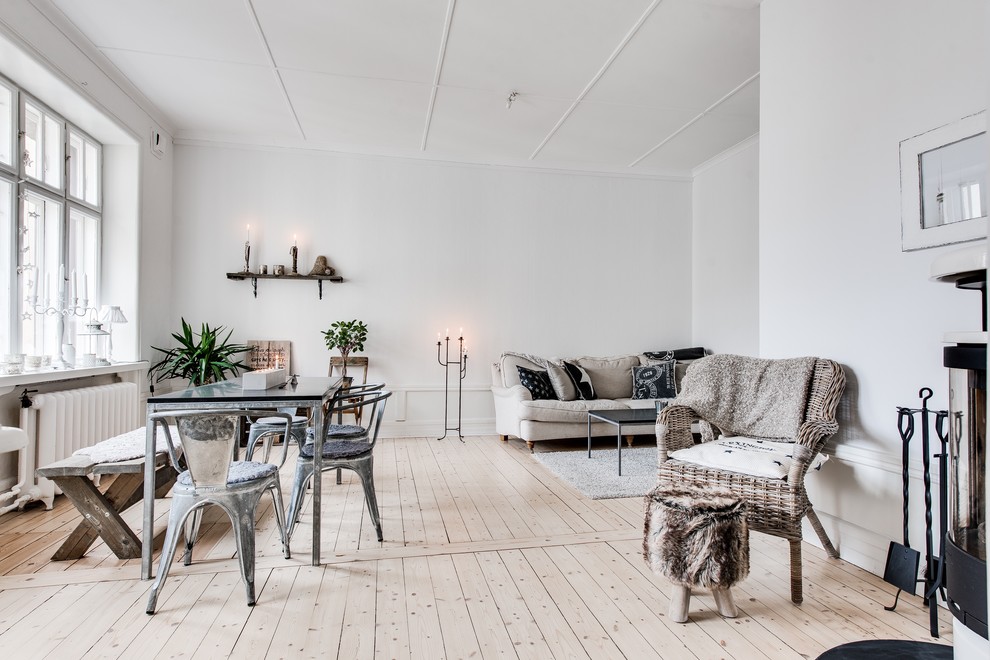 Mid-sized traditional formal open concept living room in Gothenburg with white walls, light hardwood floors, no fireplace and no tv.
