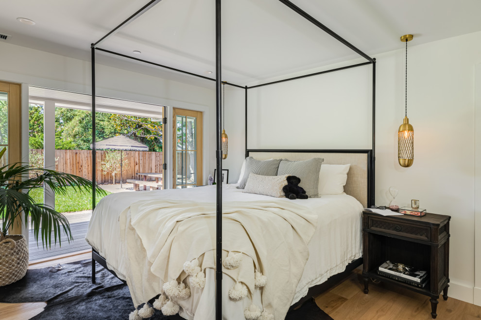 Klassisches Schlafzimmer mit weißer Wandfarbe, braunem Holzboden und braunem Boden in Orange County