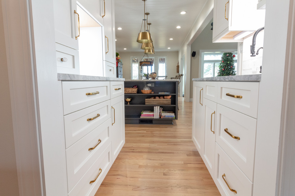 Inspiration for a large l-shaped eat-in kitchen remodel with shaker cabinets, white cabinets, granite countertops, an island and white countertops