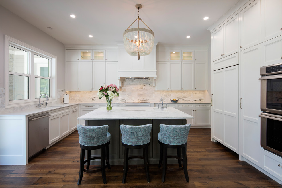 Design ideas for a mid-sized beach style u-shaped open plan kitchen in Jacksonville with an undermount sink, shaker cabinets, white cabinets, marble benchtops, stone slab splashback, stainless steel appliances, dark hardwood floors and with island.