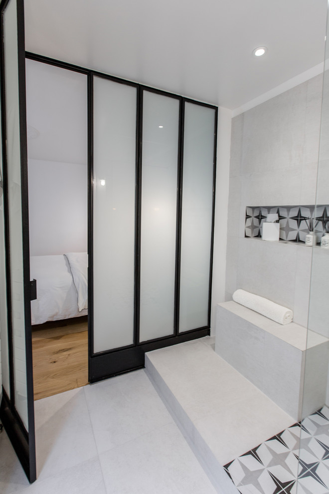 Inspiration for a small contemporary 3/4 bathroom in Paris with white cabinets, a curbless shower, gray tile, ceramic tile, grey walls, ceramic floors, a wall-mount sink and grey floor.