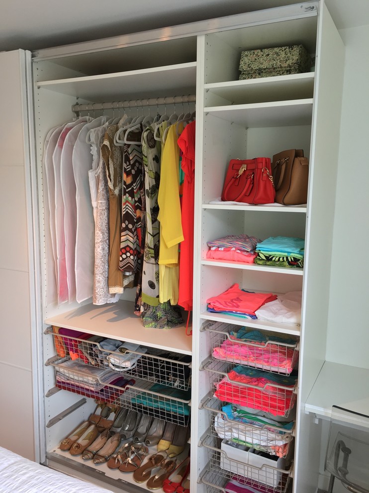 Photo of a large contemporary gender-neutral built-in wardrobe in Other with flat-panel cabinets, white cabinets and carpet.