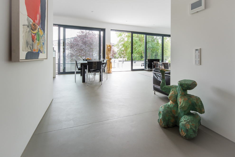 Photo of an expansive modern kitchen/dining combo in Cologne with concrete floors, grey floor and white walls.