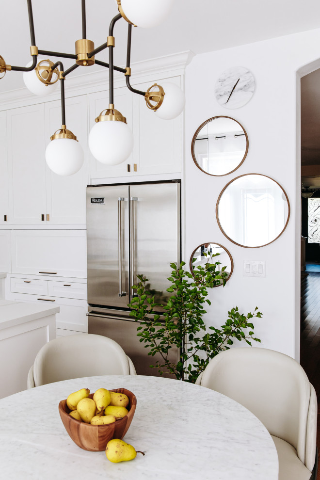 Eat-in kitchen - mid-sized transitional l-shaped dark wood floor and brown floor eat-in kitchen idea in Toronto with an undermount sink, shaker cabinets, white cabinets, quartz countertops, white backsplash, quartz backsplash, black appliances, an island and white countertops