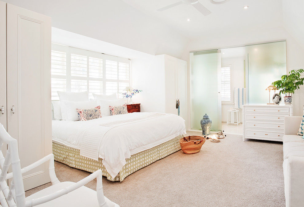 Photo of a beach style master bedroom in Los Angeles with white walls and carpet.