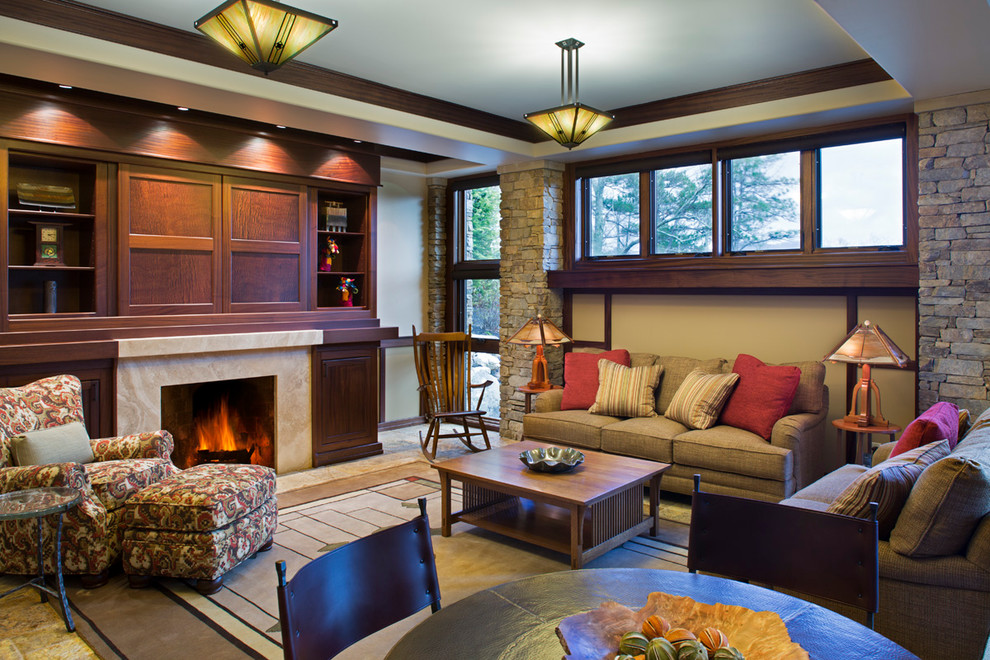 Photo of an arts and crafts enclosed family room in Other with beige walls, a standard fireplace, a stone fireplace surround and a concealed tv.