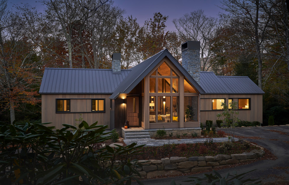 На фото: большой, двухэтажный, деревянный, бежевый частный загородный дом в стиле рустика с двускатной крышей, металлической крышей, серой крышей и отделкой доской с нащельником
