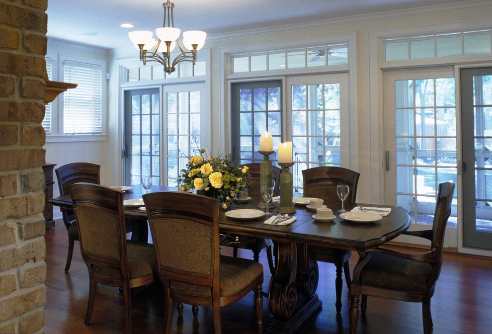 Inspiration for a mid-sized traditional separate dining room in Chicago with yellow walls, medium hardwood floors, a standard fireplace and a brick fireplace surround.