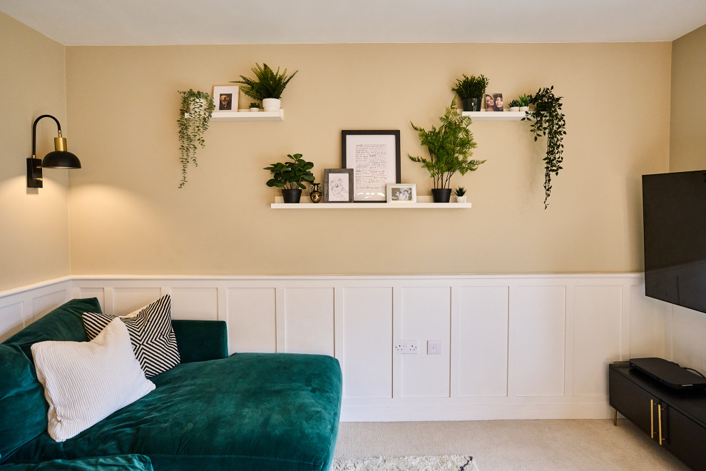 Design ideas for a mid-sized transitional formal open concept living room in Hampshire with beige walls, carpet, beige floor, panelled walls and a wall-mounted tv.