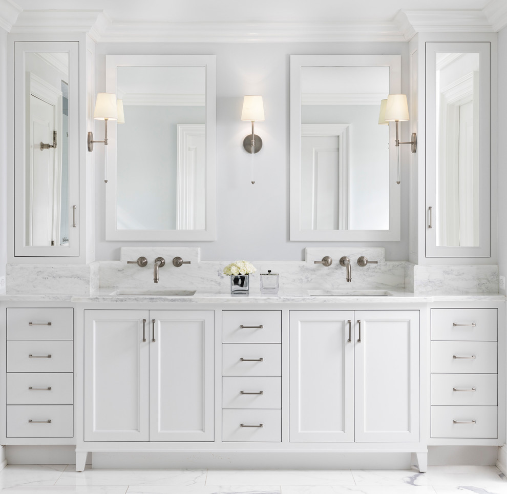 This is an example of a large transitional master bathroom in Detroit with recessed-panel cabinets, white cabinets, white tile, grey walls, an undermount sink, white floor, white benchtops, a freestanding tub, a curbless shower, a two-piece toilet, marble, marble floors, marble benchtops and a hinged shower door.