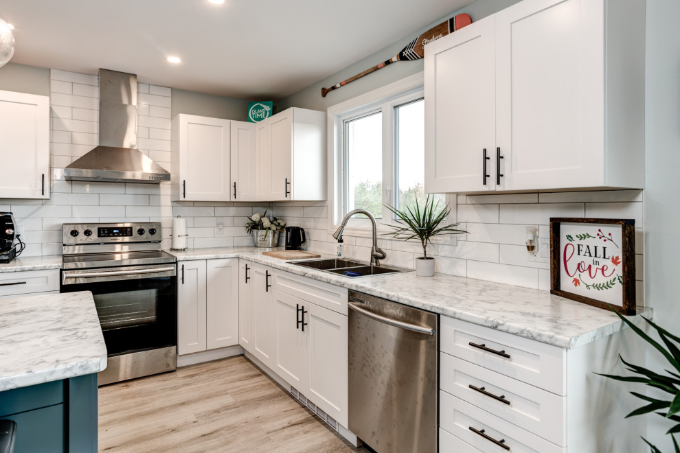 Mid-sized minimalist vinyl floor and gray floor kitchen photo with shaker cabinets, white cabinets, white backsplash, ceramic backsplash, stainless steel appliances and an island