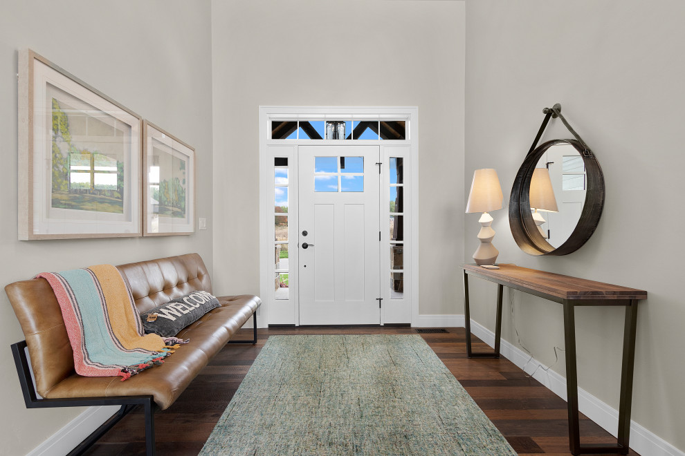 Example of a mid-sized transitional medium tone wood floor and brown floor foyer design with gray walls and a white front door