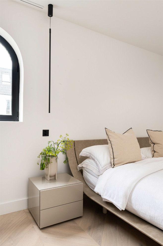 Design ideas for a large contemporary master and cream and black bedroom in London with grey walls, light hardwood flooring, no fireplace and feature lighting.