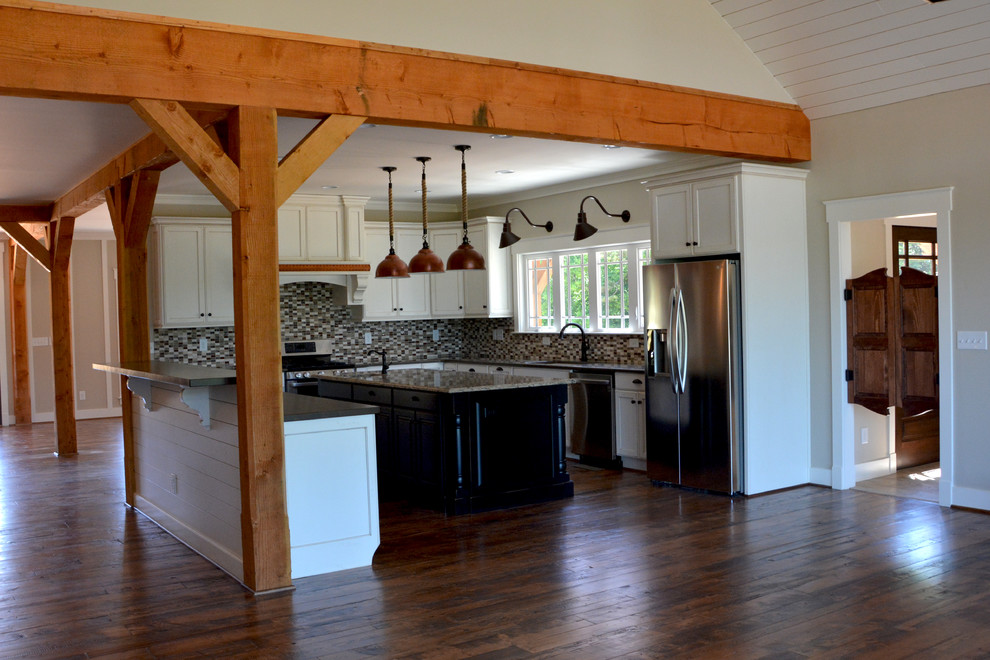 Inspiration for a large rustic dark wood floor eat-in kitchen remodel with an undermount sink, recessed-panel cabinets, distressed cabinets, granite countertops, multicolored backsplash, glass tile backsplash, stainless steel appliances and an island