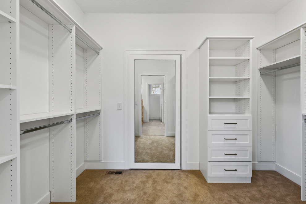 Design ideas for a large transitional gender-neutral walk-in wardrobe in Minneapolis with recessed-panel cabinets, white cabinets, carpet and beige floor.