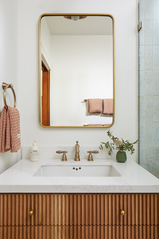 This is an example of a small traditional master bathroom in San Francisco with flat-panel cabinets, medium wood cabinets, a curbless shower, blue tile, terra-cotta tile, white walls, ceramic floors, an undermount sink, engineered quartz benchtops, white floor, a hinged shower door, white benchtops, a niche, a single vanity and a built-in vanity.