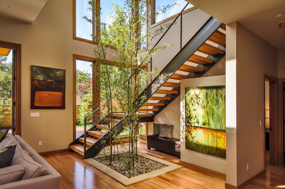 Inspiration for a large asian wood l-shaped staircase in San Francisco with open risers and cable railing.