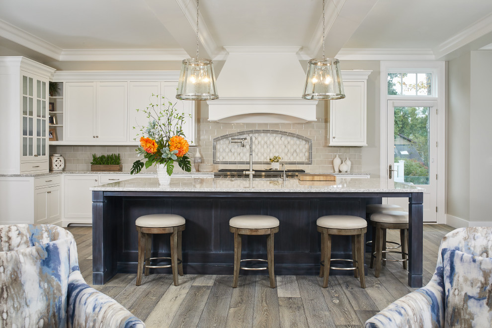 Beach style l-shaped open plan kitchen in Grand Rapids with white cabinets, quartz benchtops, beige splashback, subway tile splashback, stainless steel appliances, light hardwood floors, with island, grey floor, white benchtop, coffered and flat-panel cabinets.