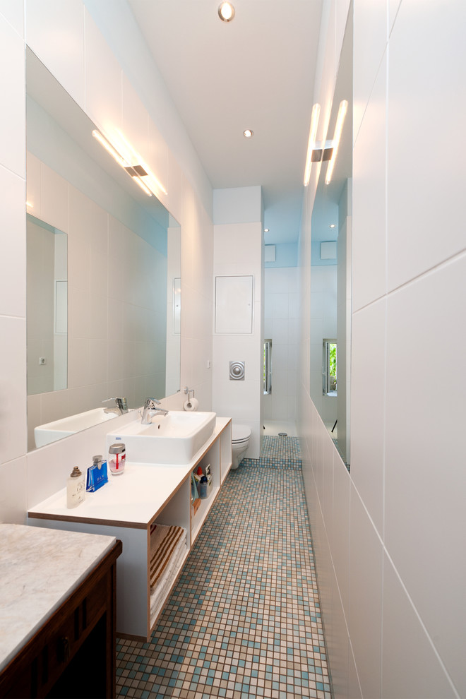 This is an example of a small contemporary 3/4 bathroom in Other with a vessel sink, open cabinets, white cabinets, an open shower, a wall-mount toilet, white tile, white walls, mosaic tile floors, ceramic tile and an open shower.