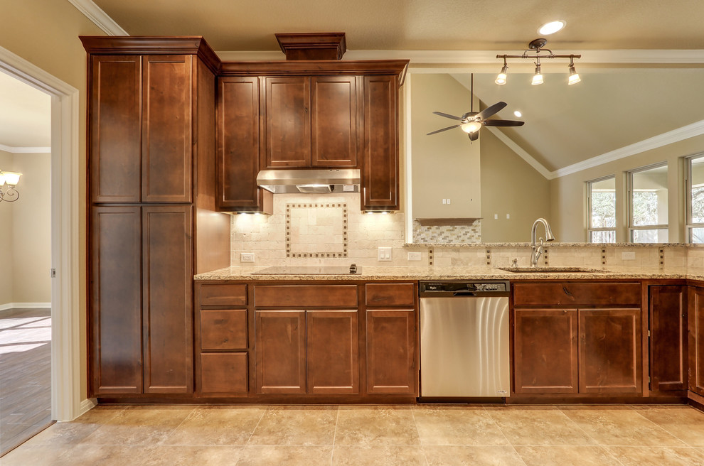 This is an example of a large transitional galley eat-in kitchen in Austin with a single-bowl sink, recessed-panel cabinets, dark wood cabinets, granite benchtops, beige splashback, stone tile splashback, stainless steel appliances, linoleum floors and no island.