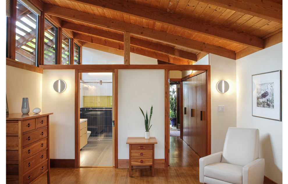 Photo of a mid-sized midcentury master bedroom in San Francisco with white walls and exposed beam.