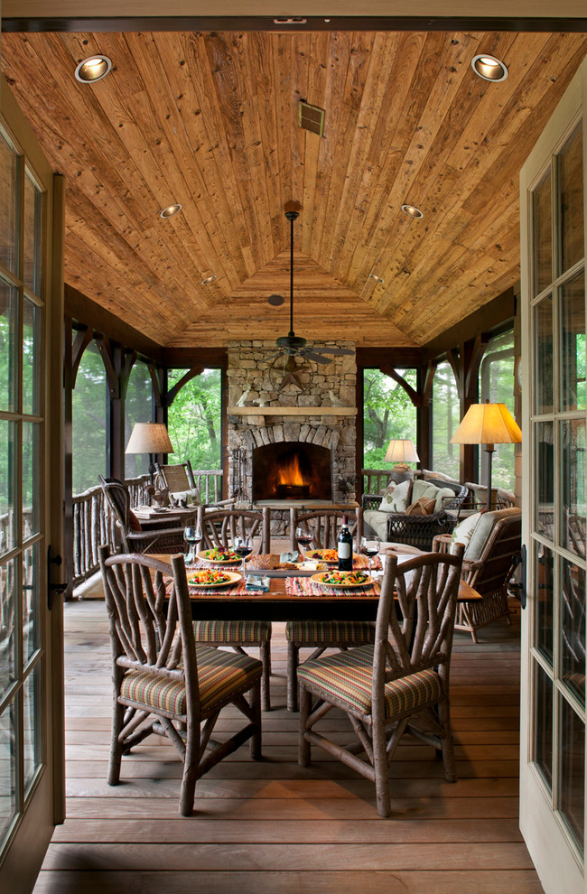 Design ideas for a country sunroom in Other with dark hardwood floors, a stone fireplace surround, a standard ceiling and brown floor.