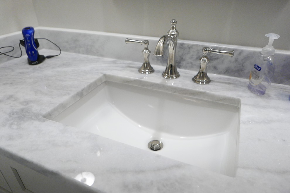 Large transitional master white tile and porcelain tile porcelain tile and white floor freestanding bathtub photo with shaker cabinets, white cabinets, a two-piece toilet, beige walls, an undermount sink, marble countertops, a hinged shower door and white countertops