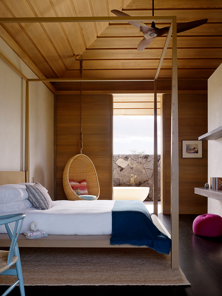 Contemporary bedroom in Hawaii with beige walls and dark hardwood floors.