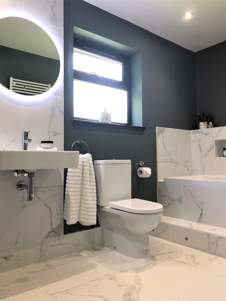 This is an example of a mid-sized modern kids bathroom in Other with a drop-in tub, a two-piece toilet, porcelain tile, porcelain floors and a wall-mount sink.
